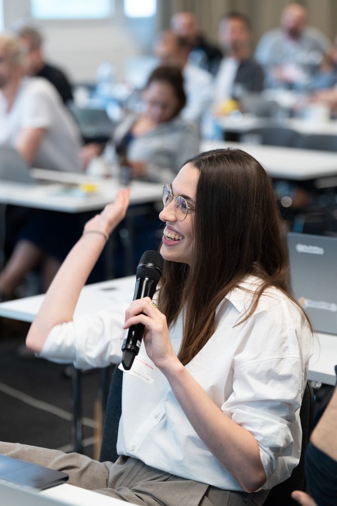 A participant asking a question with a microphone during the tutorial